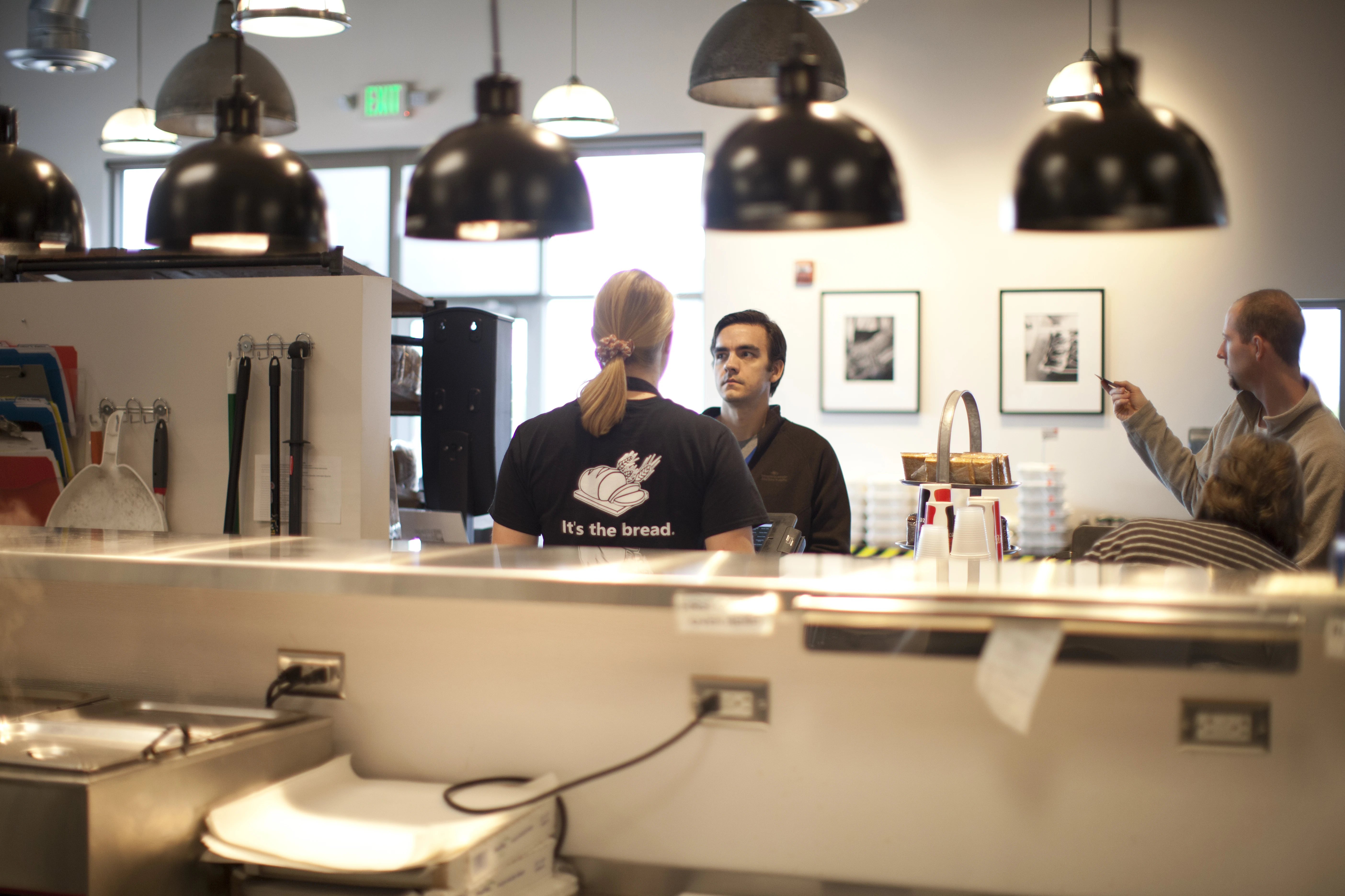Village Baker team member serving customers behind the counter